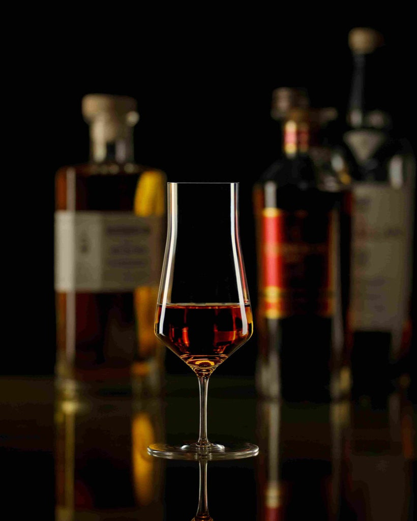 Verre Zalto Denk'Art Cask avec whisky et bouteilles en arrière-plan
